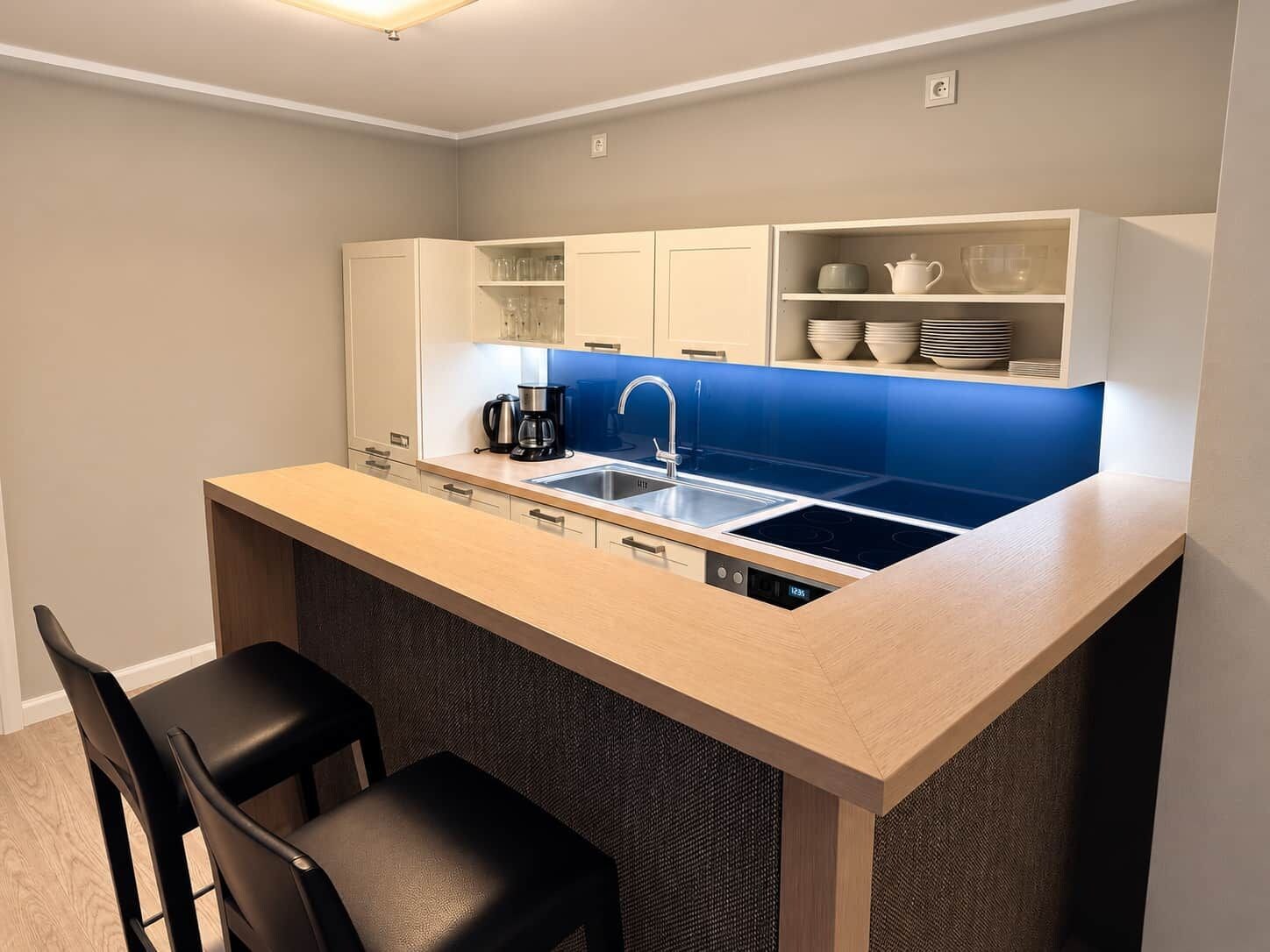 A compact kitchen with a built-in island, a coffee maker, and a sink.