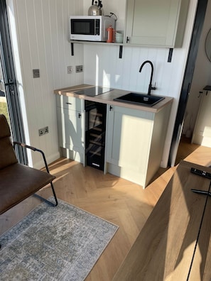 Una cocina compacta con microondas, lavabo y horno integrado.