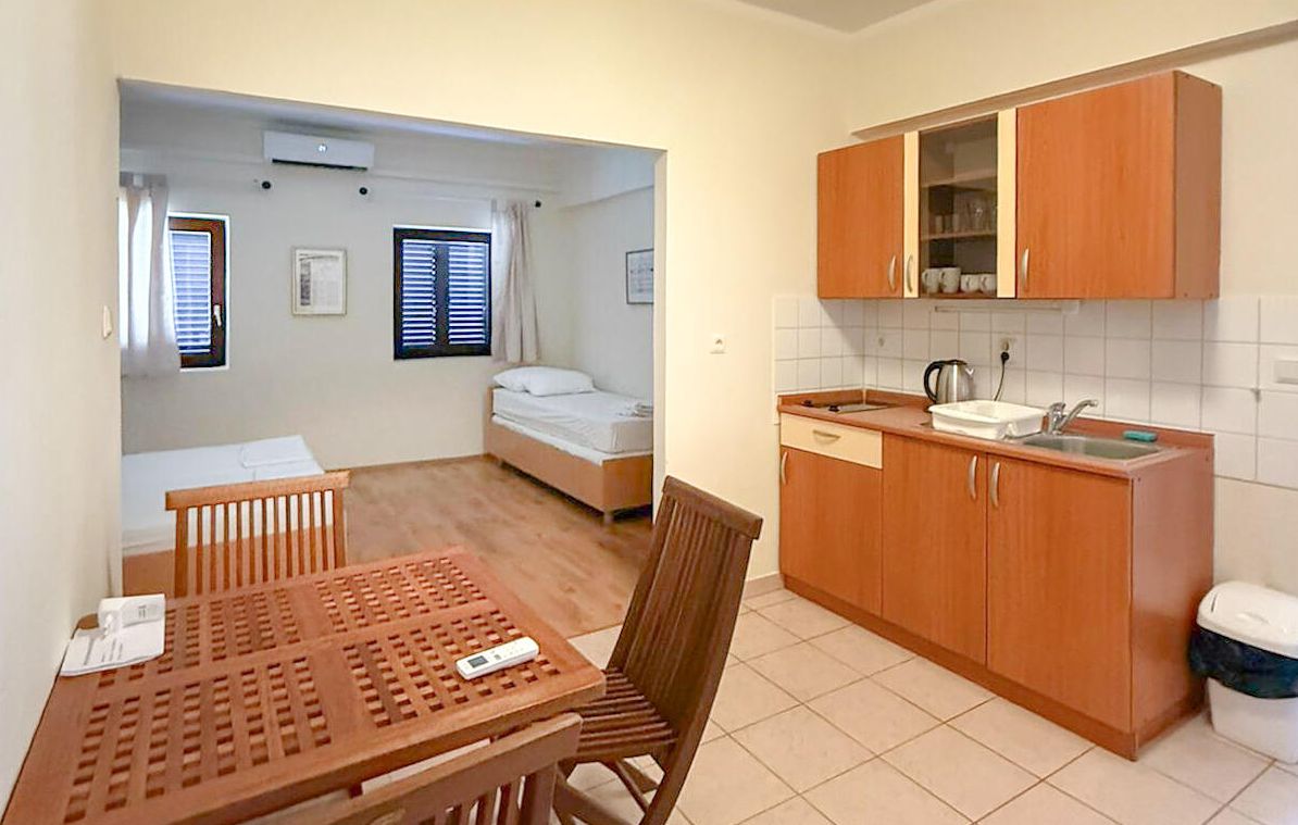 Habitación compacta con kitchenette, una cama y comedor.