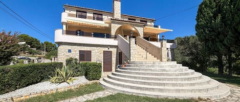 A multi-story building with a central staircase leading to the entrance.