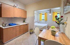 A compact kitchen with a sink, cabinets, and a dining area with a table and chairs. - Awesome apartment in Rab with WiFi (Rab)