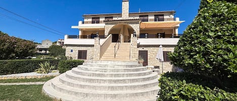 A two-story building with a stone staircase leading to the entrance.