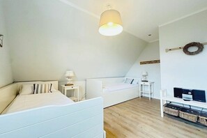 A bedroom with a bed, bedside tables, a desk, a computer, and a TV. - Holiday home in St. Peter-Ording with Wi-Fi (St. Peter-Ording)