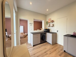 A compact kitchen with a washing machine, microwave, and a small countertop. - Bright house for two, 200 m from the sea (Fouras)