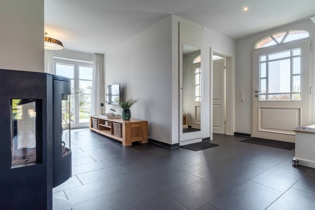 A spacious living area with a fireplace, a wooden console table, and a large window.