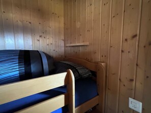 A wooden bunk bed with a blue mattress and a striped pillow. - Schirli Dachgeschoss Appartement/Fewo, Bad, WC 6-Bettwohnung by Interhome (Rosswald)