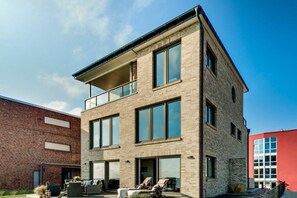 A multi-story building with a flat roof, large windows, and a balcony. - Holiday apartment with 2 bedrooms (Kappeln)