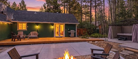 Una terraza de madera con mobiliario exterior y una chimenea.