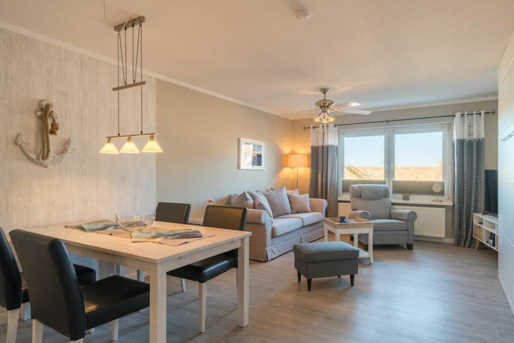A modern living room with a dining area, a sofa set, and a television.