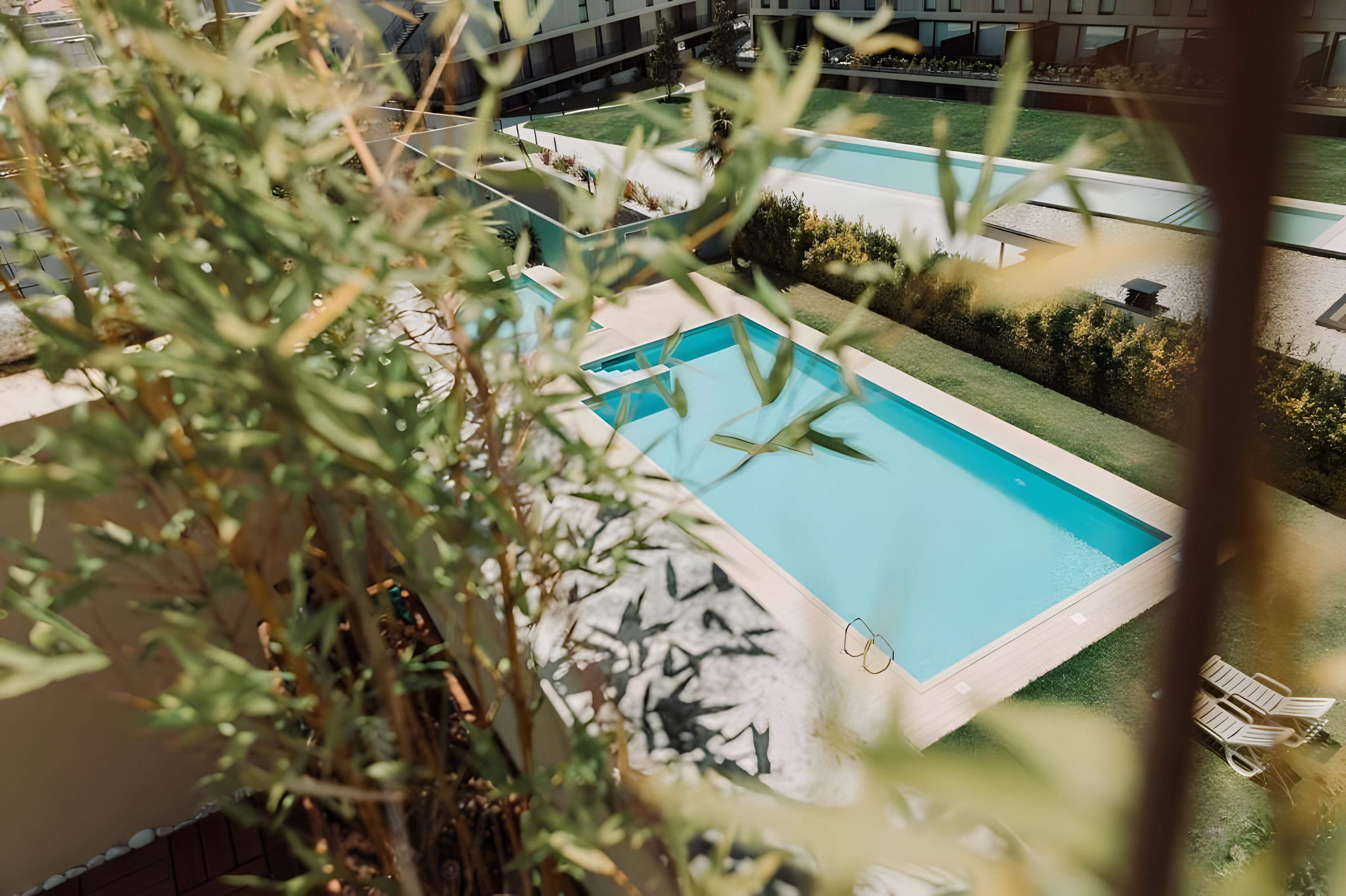 Une piscine avec vue sur un bâtiment en arrière-plan.