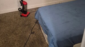 A room with a single bed, a vacuum cleaner, and a wall socket. - Welcoming to topspad in charming Fresno (Fresno)