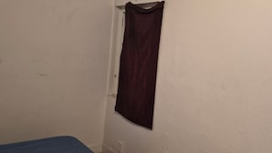 A room with a single bed, a window with a curtain, and a wall-mounted light fixture. - Welcoming to topspad in charming Fresno (Fresno)
