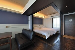 A modern hotel room with a bed, a seating area, and a view of the outdoors. - Smile Smart Inn Okinawa Churaumi (Motobu, Kunigami District)