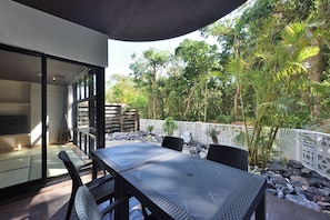 An outdoor dining area with a table and chairs, surrounded by a garden with various plants and a white fence. - Smile Smart Inn Okinawa Churaumi (Motobu, Kunigami District)
