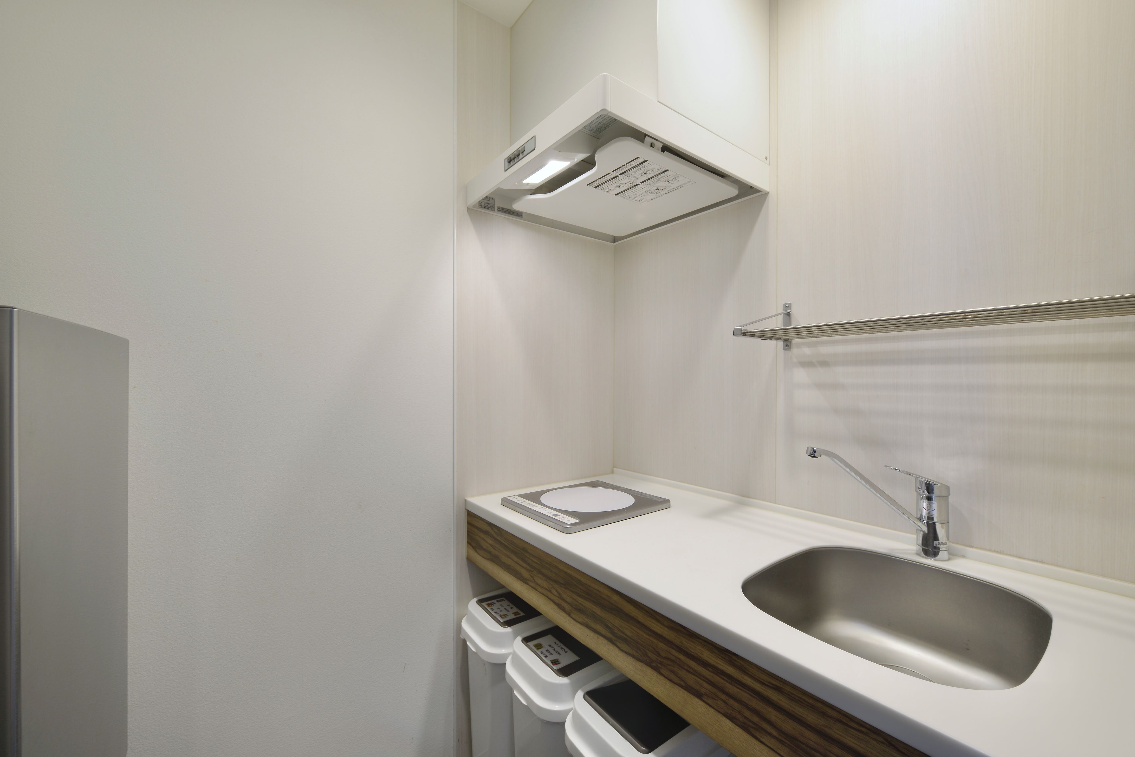 Een moderne badkamer met een inbouwwastafel, een spiegel en een handdoekrek.