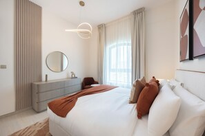 Un dormitorio moderno con cama, cómoda, espejo y ventana con cortinas.