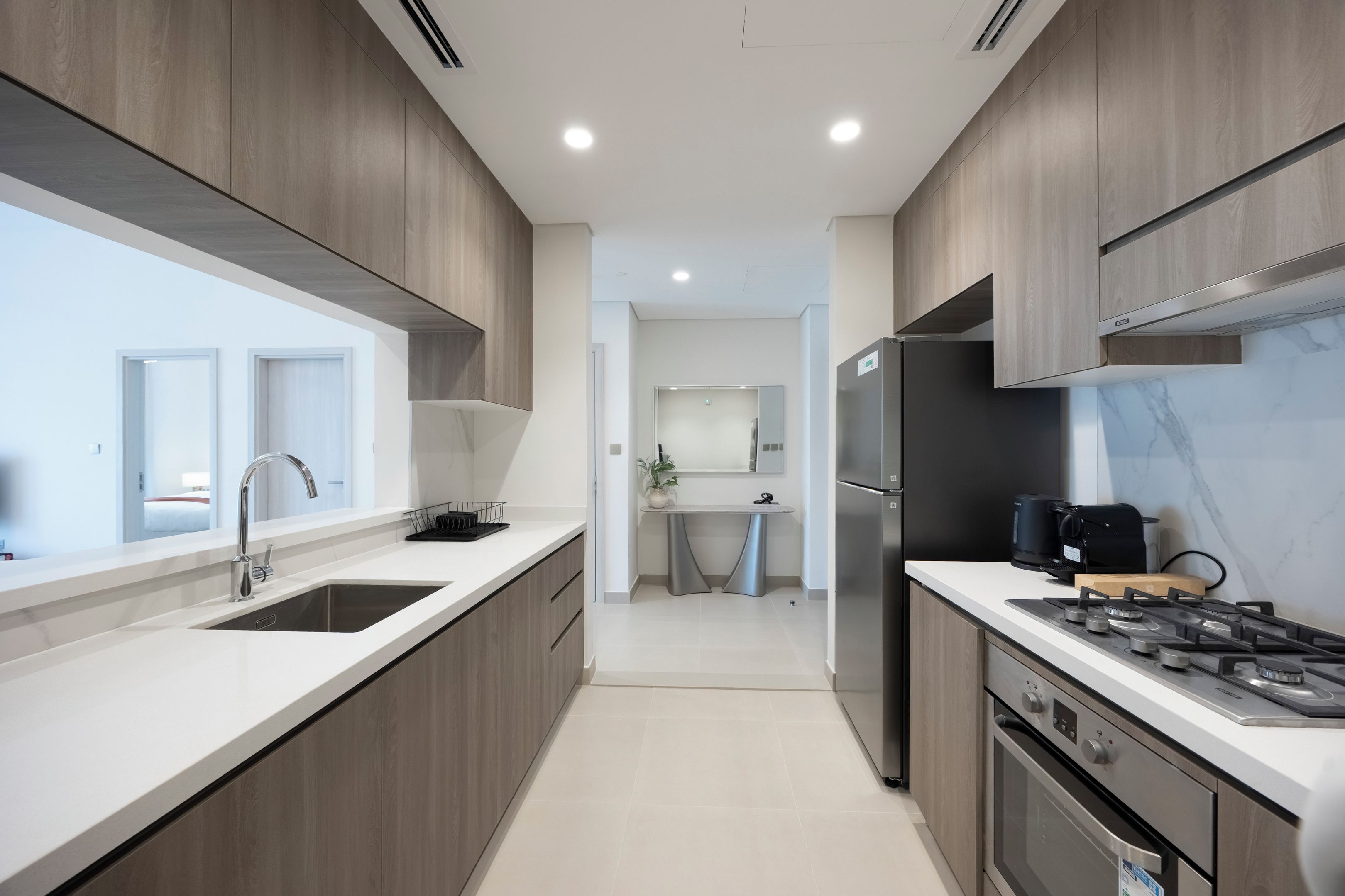 Una cocina moderna con una isla central, electrodomésticos de acero inoxidable y vistas al área de estar contigua.