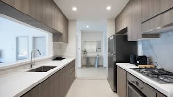 Una cocina moderna con una isla central, electrodomésticos de acero inoxidable y vistas al área de estar contigua.