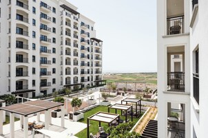 A multi-story hotel with outdoor seating areas and a view of the landscape.