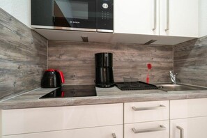 A kitchen with a Bosch microwave, a coffee maker, and a sink. - Utholm 3 Morning sun (St. Peter-Ording)