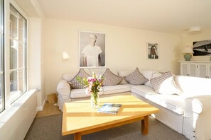 A living room with a sofa, a coffee table, and a window. - Holiday home with 2 bedrooms (Sylt \/ OT Tinnum)