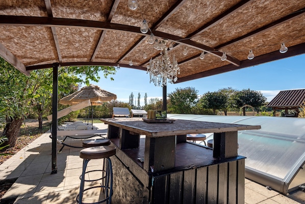An outdoor patio with a bar area, seating, and a pool. - Holiday Home "Domaine Logis Gascogne, Gîte 1": Mountain View, Pool, and Wi-Fi Included (Saint-Justin)