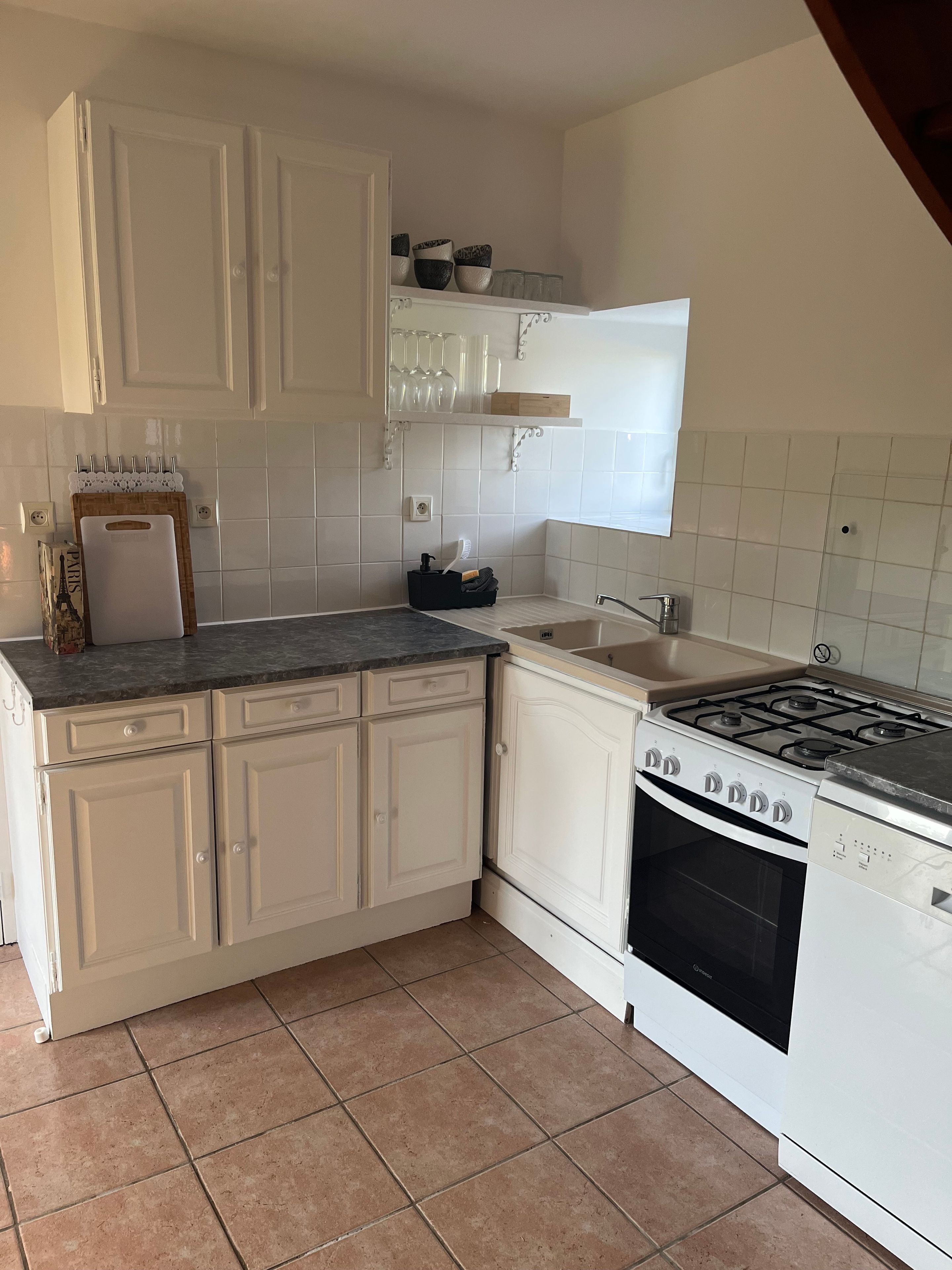 A kitchen with white cabinets, a stove, and a sink.