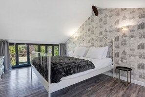 Une chambre à coucher avec un lit, une fenêtre et un mur orné d’un motif.