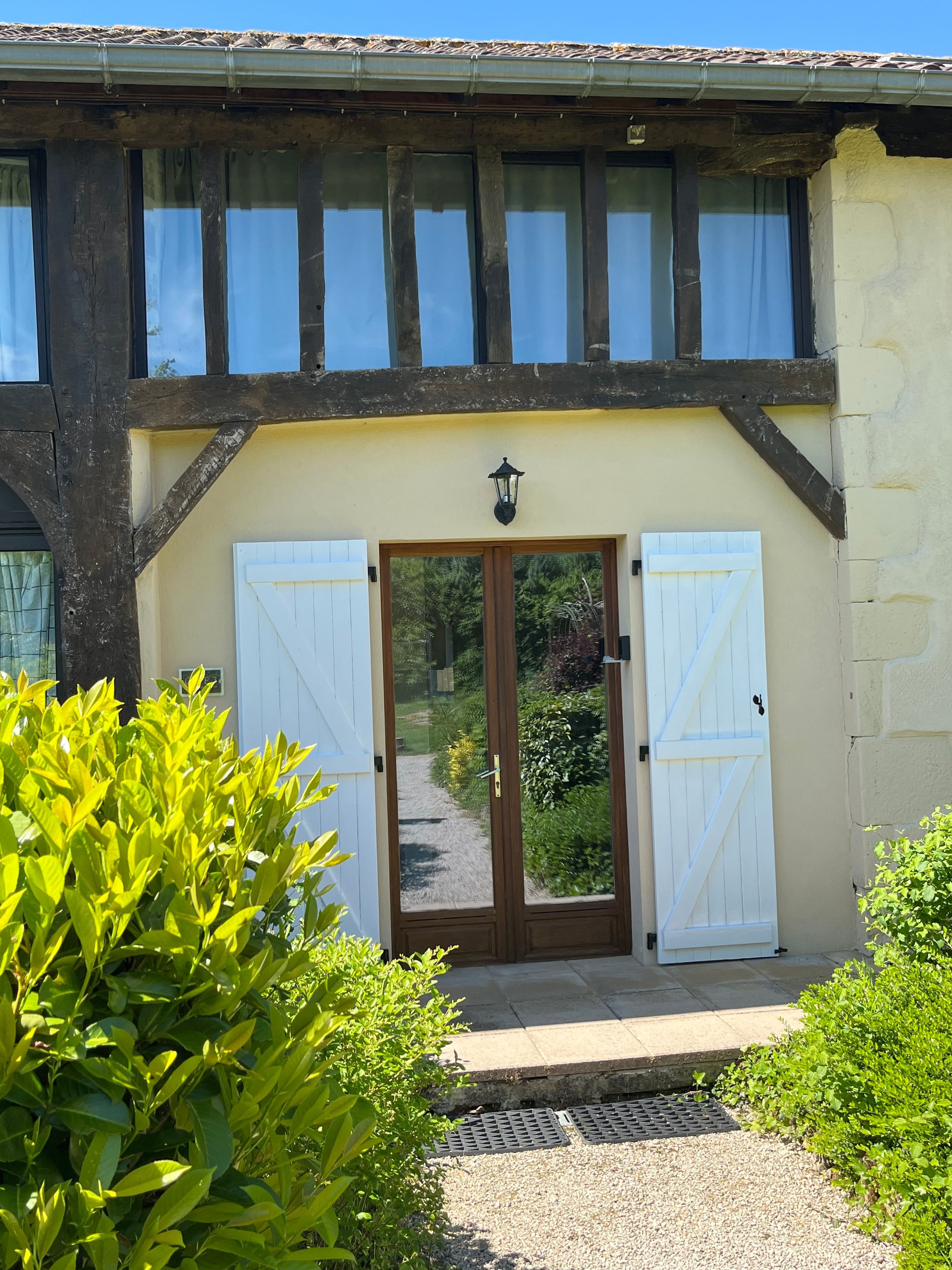 Un bâtiment à l’architecture traditionnelle, caractérisé par une façade en bois et une entrée centrale dotée d’une porte et de volets.