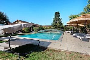 A swimming pool with lounge chairs and umbrellas, surrounded by grass and trees. - Holiday Home “Domaine Logis Gascogne, Gîte 3” Mountain View, Pool & Wi-Fi (Saint-Justin)