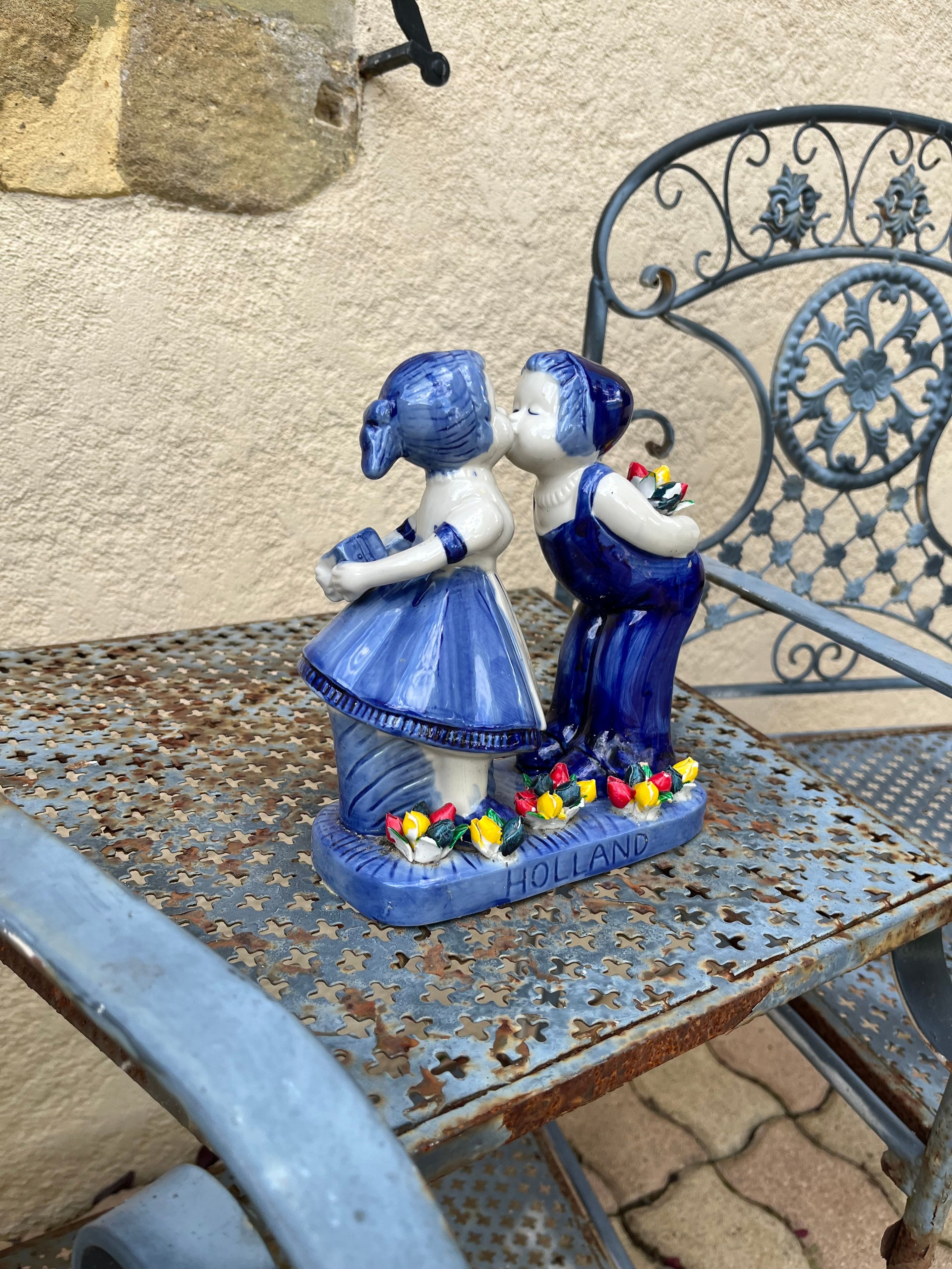 Una mesa de metal con una figurita de cerámica decorativa con la imagen de dos personas.