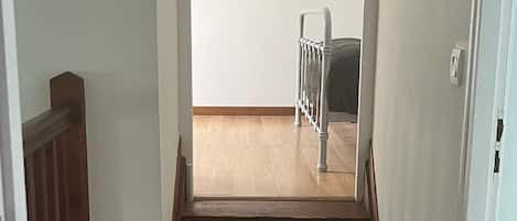 Un escalier menant à un balcon doté d’une rambarde en métal.