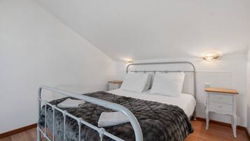 Een slaapkamer met een bed, nachtkastjes en een hoofdbord.