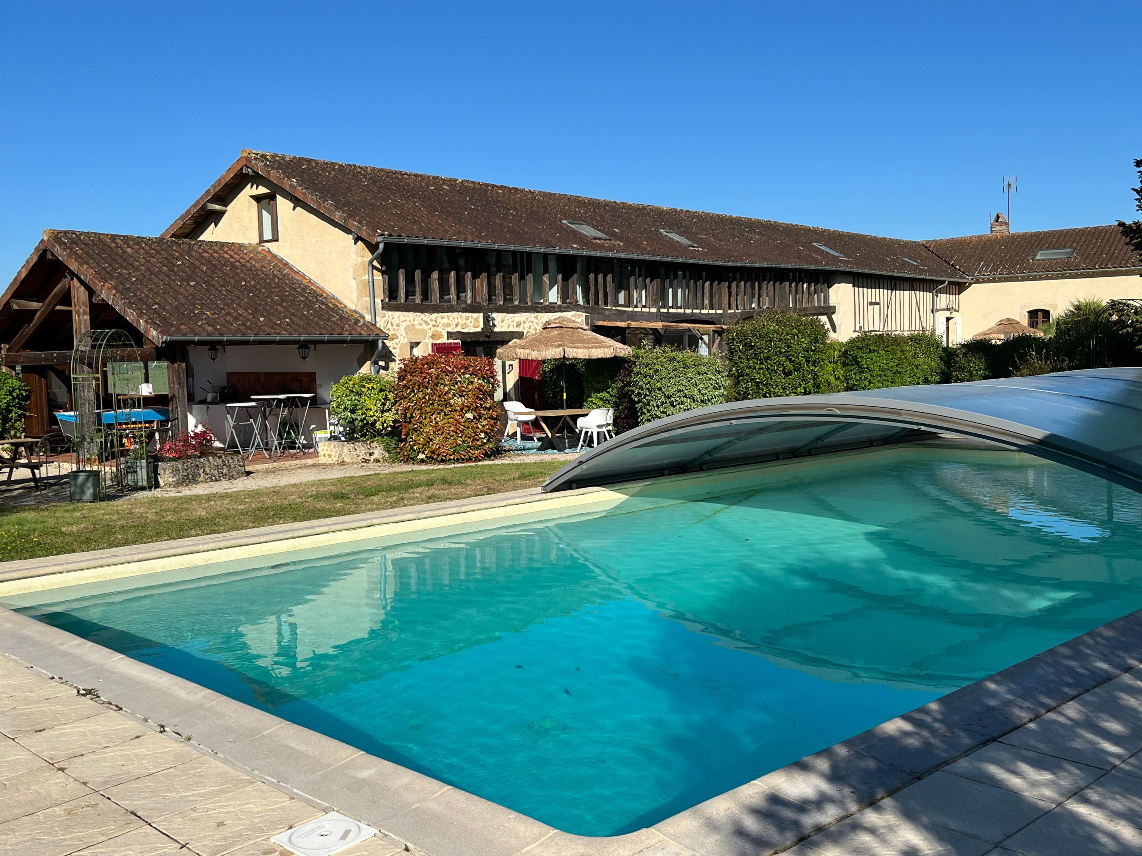 Ein Schwimmbecken mit glasklarer, blauer Wasserfläche, umgeben von einer Steindeck.