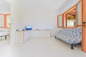A clean, modern room with a white cabinet, a blue television, and a patterned sofa. - Appartements mit Swimming Pool, Andora (ANDORA (SAVONA))