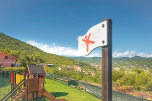 A playground with a climbing structure and a signpost with a symbol. - Appartements mit Swimming Pool, Andora (ANDORA (SAVONA))