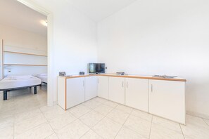 A small, modern kitchen with a wooden countertop, cabinets, and a television. - Appartements mit Swimming Pool, Andora (ANDORA (SAVONA))