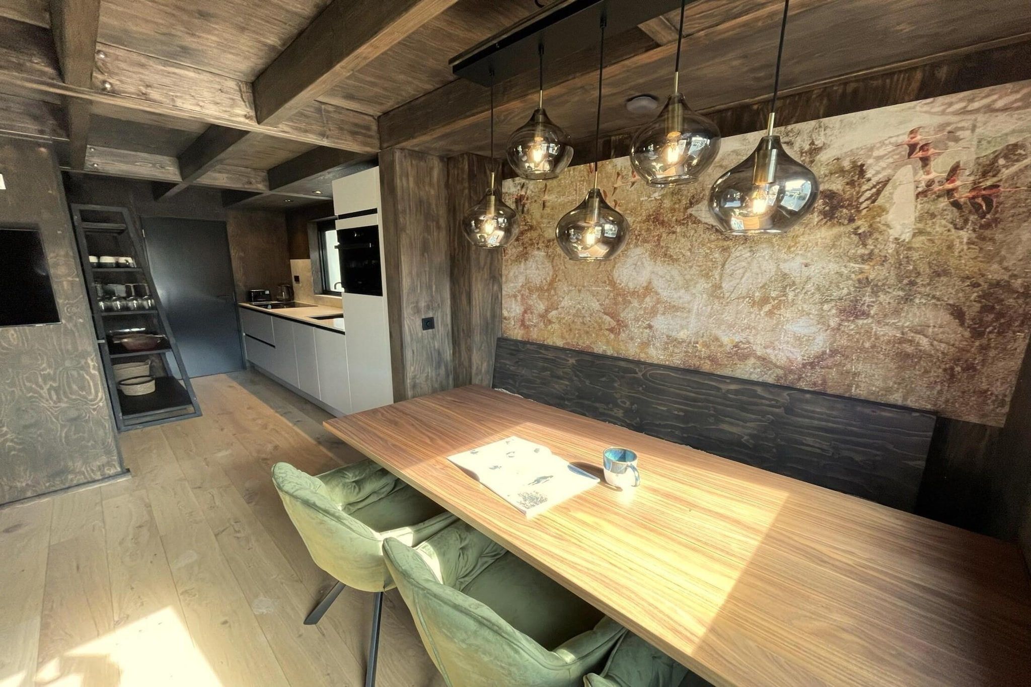 Une cuisine moderne avec un plan de travail en bois, un four encastré et un luminaire suspendu.
