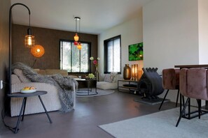 Una sala de estar moderna con un sofá, una mesa redonda, una chimenea y un televisor.