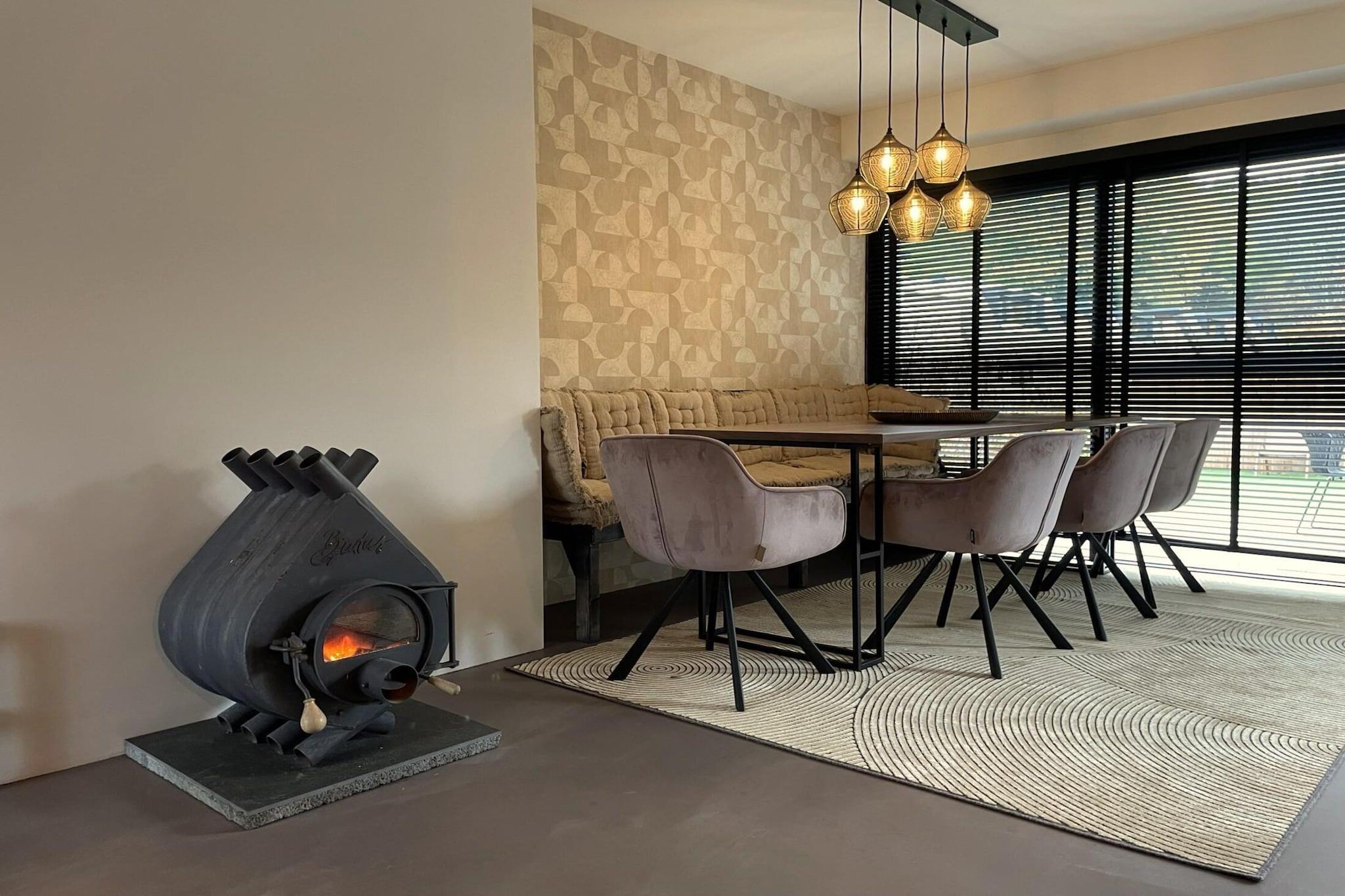 A modern dining area with a built-in wood-burning stove, a sofa, and a dining table with chairs.