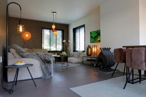 Un salon moderne avec un canapé, une table basse, une cheminée et un téléviseur.