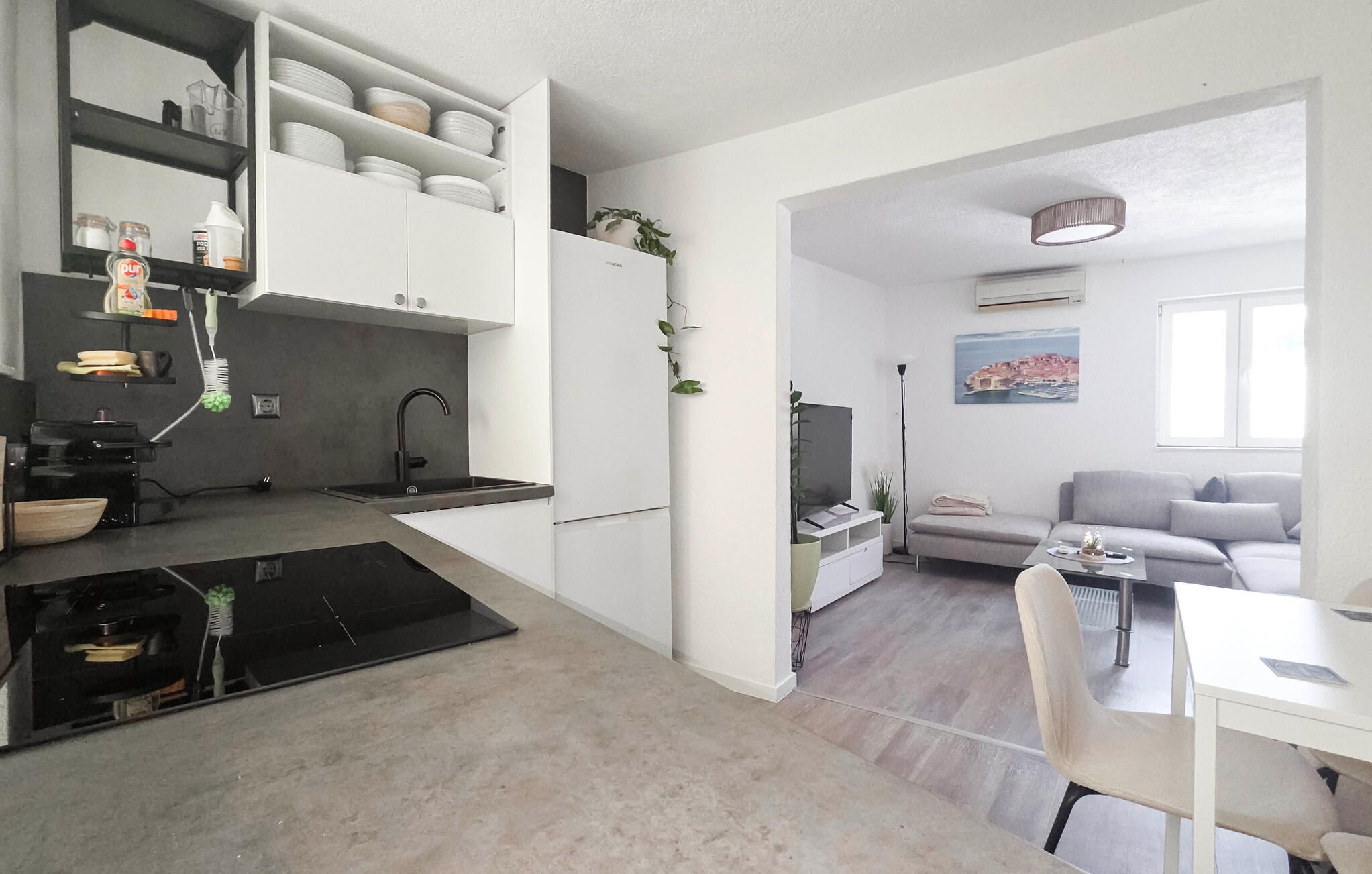 Un espace de vie compact comprenant un coin cuisine, un coin repas et un espace détente avec vue.