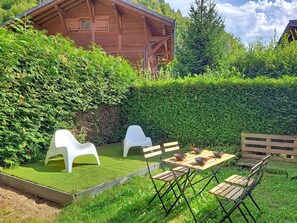 Eine Holzhütte mit einer Terrasse und einer Sitzgelegenheit im Freien.