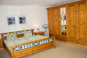 Una camera da letto con un letto di legno, comodini, un armadio e decorazioni alle pareti.