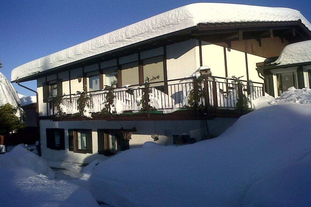 Un bâtiment à deux étages doté d’un balcon, entouré de neige.
