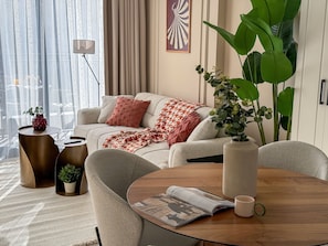 Un salon moderne avec un canapé, une table basse et une grande plante.
