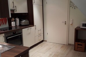 A kitchen with a microwave, toaster, and oven. - Holiday apartment with 2 bedrooms (Bispingen)