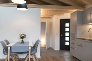 A modern kitchen with white cabinets and a wooden countertop. - Holiday apartment with 1 bedroom (Garmisch-Partenkirchen)