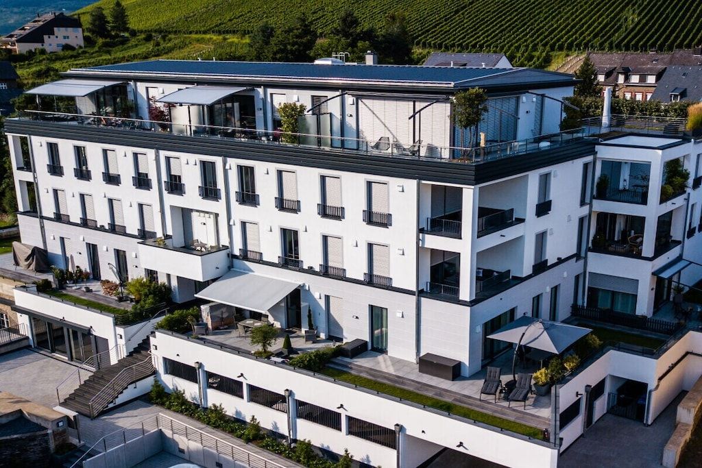 A multi-story hotel with balconies, a flat roof, and a modern architectural style.