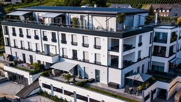 Et hotel med flere etager, altaner, et fladt tag og moderne arkitektur.